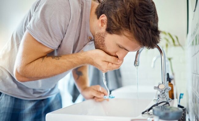 Man washing mouth after brushing teeth