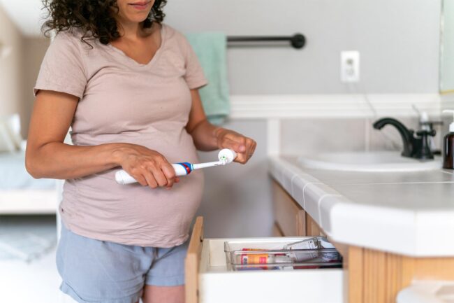 Pregnant woman brushing teeth